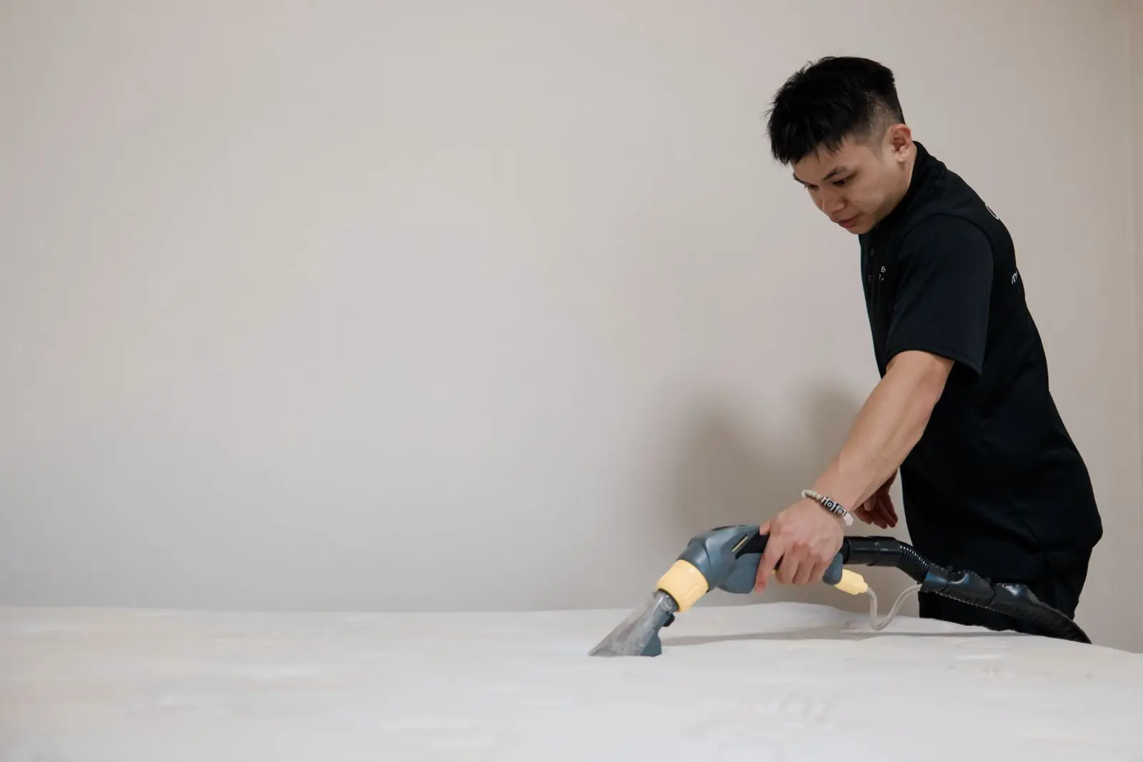 A Cleancraft technician running an extraction tool across a mattress