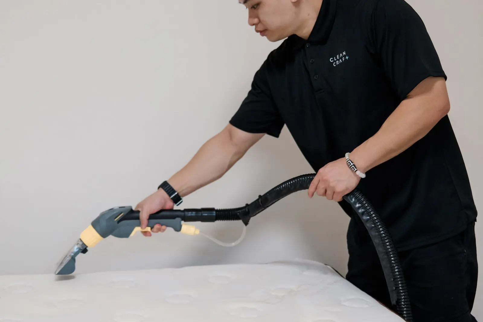 A Cleancraft technician cleaning a mattress with a handheld extraction tool